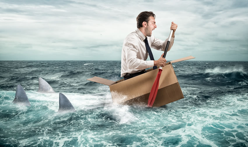 man in ocean escaping sharks seaking Debt Relief